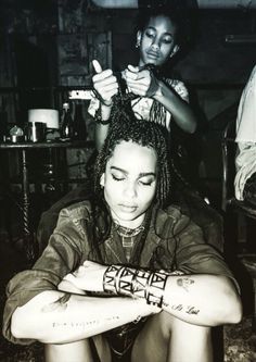 a woman is getting her hair done by another woman with tattoos on her arm and leg