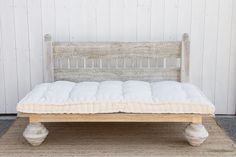 an old wooden bed frame with white mattress on the bottom and footrests in front