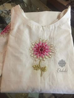 a white shirt with pink and gold flowers on the front, along with other clothing items