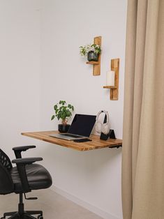 a laptop computer sitting on top of a wooden desk next to a black leather chair