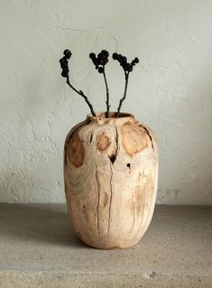 a wooden vase that has some flowers in it