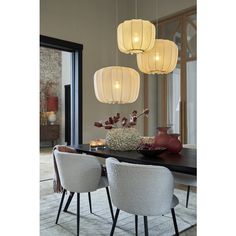 a dining room table with chairs and lights hanging from it