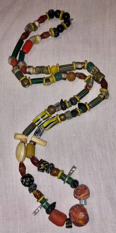 This is a fabulous 30 inch strand of assorted beads and amulets just filled with VERY collectible and somewhat rare antique beads. The tribal inspired 20-30 year old assemblage boasts a really great collection and is ready to wear or re-purpose. Beads are in good pre-owned condition with expected wear. The necklace has been strung for a while and will eventually need to be restrung. I do NOT guarantee any stringing, so bear that in mind. Antique and vintage necklaces like this are often on old s Unique Hand-strung Healing Beads, Vintage Beaded Necklace With Gemstone Beads For Festival, Vintage Beaded Necklaces With Gemstone Beads For Festivals, Vintage Gemstone Beaded Necklaces For Festivals, Vintage Multicolor Round Beads, Vintage Polished Beads For Festivals, Amulet Style Beaded Necklace With Large Oval Beads, Amulet Style Necklace With Large Round Beads, Vintage Multicolor Beads And Cabochons For Healing