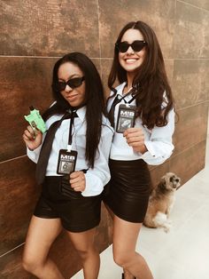 two women dressed in black and white posing for the camera