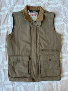 "Vintage cargo / hunting vest Zipper and snap button closure Fully lined 3 pockets 100% cotton Leather collar *one small mark on back Measurements: Chest: 44\" around Length: 28\"" Sleeveless Outerwear With Flap Pockets For Outdoor, Sleeveless Outdoor Outerwear With Flap Pockets, Brown Cotton Vest With Pockets, Fall Cotton Vest With Side Pockets, Vintage Cotton Vest For Outdoor, Cotton Vest With Patch Pockets For Fall, Brown Cotton Vest For Outdoor Use, Brown Cotton Vest For Outdoor Activities, Brown Cotton Vest For Outdoor