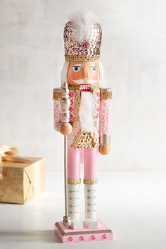 a wooden nutcracker is standing next to a box