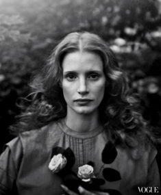 a black and white photo of a woman holding flowers