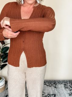 Our Nonchalant knit cardigan offers a cozy v-neck and split hem, perfect for a casual day out. The button down design adds a touch of elegance, while the copper color adds a pop to any outfit. With a fitted silhouette and a blend of 75% acrylic and 25% nylon, this cardigan is both stylish and comfortable. Amanda is wearing a small, Betty a medium. Besties: Reverse It, Flexible, Laid Back, Dress Up, LBD, Longer Days, The Staple, Hey Boots, Informal, Day Trip, Beloved Blazer Brown V-neck Cardigan For Layering, Casual Brown V-neck Sweater For Work, Everyday Solid V-neck Cardigan, Everyday Solid Color V-neck Cardigan, Everyday V-neck Cardigan, Fall Button-up Cardigan For Loungewear, Versatile V-neck Cardigan With Button Closure, Brown V-neck Sweater With Button Closure, Trendy V-neck Cardigan For Layering