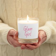 a person holding a candle in their hands with the words glam girl on it