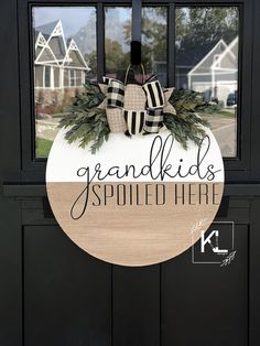 a black and white door with a wooden sign that says grandkids spoiled heart