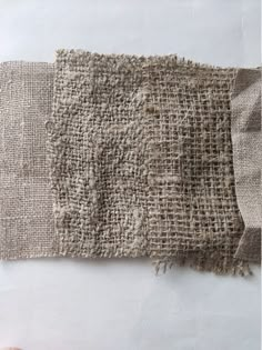 a piece of fabric that has been woven on to the side of it, and is being held up by someone's hand