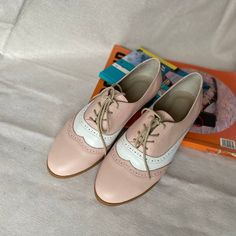 Step into retro elegance with these vintage-inspired pink and white leather oxford shoes. Designed for women who appreciate a blend of classic and contemporary, these oxfords feature delicate wingtip details and a timeless lace-up design. Handcrafted from high-quality leather, these shoes offer both comfort and durability, making them perfect for both workdays and casual outings. The soft pink paired with white detailing creates a feminine and playful look, ideal for those who want to add a touc Shoes For Woman, Oxford Flats, Leather Brogues, Leather Oxford Shoes, Brogue Shoes, Women Oxford Shoes, Tie Shoes, Vintage Shoes, Color Combination