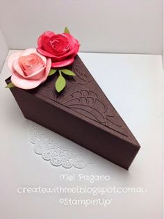 a piece of chocolate cake with pink flowers on top and white doily around the edges