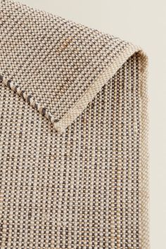 a close up view of the back of a chair with a beige and black checkered fabric