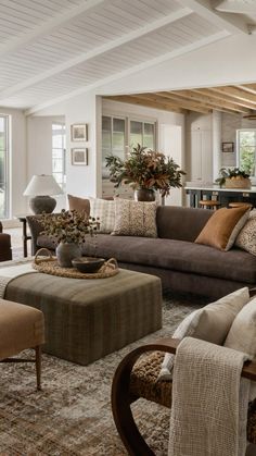 a living room filled with lots of furniture and decor on top of carpeted flooring