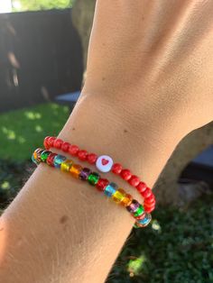 Circular red beads sealed with a heart for lasting luck in love combined with a multi color strand of glass seed beads! - Standard bracelet size is 7 inches. Please message me if you have smaller or larger wrists. Gift Heart Bracelet With Colorful Round Beads, Red Bohemian Jewelry With Letter Beads, Bohemian Red Jewelry With Letter Beads, Bohemian Red Heart-shaped Bracelet, Everyday Red Jewelry With Colorful Beads, Multicolor Beaded Heart Bracelet For Gift, Multicolor Heart-shaped Beaded Bracelets For Friendship, Red Bohemian Bracelets With Letter Beads, Heart-shaped Friendship Bracelets With Tiny Beads