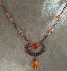 The rolo chain is bright copper and the TierraCast Poppy Festoon link is an antique copper and is 26x37mm.  The beads are a transparent light orange and the druks are wire wrapped to the chain.   The chain is 22" long and has a TierraCast hook and eye closure.  The matching earrings are a little over 1" long from the base of the ear wire to the bottom of the dangle. Nickel-free Rust-colored Metal Jewelry, Vintage Handmade Copper Jewelry, Vintage Handmade Rust Jewelry, Orange Vintage Copper Jewelry, Bronze Copper Necklace With Lobster Clasp, Handmade Rust Copper Necklaces, Orange Copper Wire Jewelry For Gifts, Orange Copper Wire Jewelry As A Gift, Handmade Rust-colored Copper Necklaces