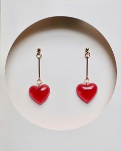 Add some love to your accessory collection with these cute and simple red heart drop earrings. These earrings feature a classic heart shape charm that is made of red resin and hangs from a gold-filled wire. The heart charm is small and dainty, making these earrings a perfect choice for those who prefer a more understated look. These earrings are lightweight and comfortable to wear, making them perfect for everyday wear. The vibrant red color is sure to add a pop of color to any outfit. These ear Drop Earrings Simple, Valentine Earrings, Earring Simple, Red Heart Earrings, Heart Earring, Valentines Earrings, Heart Drop Earrings, Wedding Jewelry Earrings, Holiday Jewelry