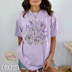 "Lavender Botanical Wildflower Comfort Colors Shirt, English Lavender Botanical T shirt, Wildflowers Tshirt for Nature and Garden Plant Lovers The C1717 Comfort Color shirt with a lavender plant on it is a charming and stylish addition to any wardrobe. Made from high-quality, ultra-soft cotton, this shirt is incredibly comfortable to wear and will quickly become a favorite. The lavender plant design on the shirt is beautifully rendered, with delicate shades of purple and green that capture the e Spring Purple Printed T-shirt, Spring Purple T-shirt With Graphic Print, Summer Purple Printed T-shirt, Purple Printed Summer T-shirt, Summer Lavender Tops With Graphic Print, Lavender Graphic Print Tops For Summer, Lavender Tops With Graphic Print For Summer, Casual Purple Floral Print Shirt, Lavender Relaxed Fit Casual Top