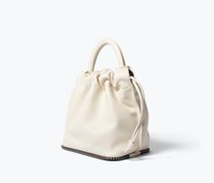 The effortless way to carry your everyday. Made by hand with bone calf, the RUBY is your classic bucket bag finished with our iconic notched welt and top handle or crossbody strap for choice of carry. The microsuede-lined interior is secured with an adjustable drawstring to keep your essentials safe when you’re on the go. Cream Bucket Bag With Handle Drop, Cream Leather Bucket Bag With Top Carry Handle, Cream Leather Bucket Bag With Top Handle, Cream Crossbody Bucket Bag With Top Carry Handle, Cream Top Handle Bucket Bag, Chic Everyday Top Handle Bucket Bag, Sandals For Sale, Flat Sneakers, Heeled Loafers