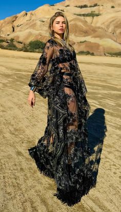 Step into the spotlight with this exquisite sheer long embroidered festival dress in captivating black and silver hues. Delicately crafted with intricate embroidery, this enchanting dress exudes elegance and allure. The mesmerizing fringe detail along the bottom adds a touch of bohemian flair, perfect for embracing your free-spirited style. Whether you're dancing under the stars at a festival or making a statement at a special event, this dress is sure to turn heads and leave a lasting impressio Sequin Dresses For Evening Festivals, Sequined Summer Evening Kaftan, Summer Evening Kaftan With Sequins, Sequined Kaftan For Evening In Summer, Sequin Kaftan For Evening And Summer, Bohemian Lace Maxi Dress For Party, Spring Party Kaftan With Sequins, Bohemian Sequin Kaftan For Parties, Glamorous Floor-length Lace Maxi Dress