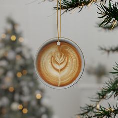 an ornament hanging from a christmas tree with a cup of coffee in the shape of a leaf