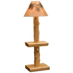 a lamp that is sitting on top of a wooden stand with a pine tree design