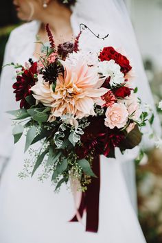 a bride holding a bouquet of flowers in her hand