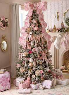 a decorated christmas tree with pink bows and presents