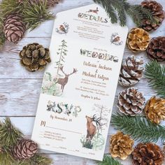 the wedding stationery is surrounded by pine cones and evergreen branches, which are scattered around