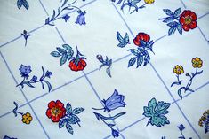 a table cloth with flowers on it and blue grids in the backround