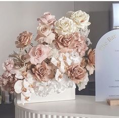 a bouquet of flowers sitting on top of a table next to a card and plaque