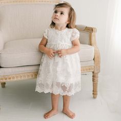 Handmade in the USA Our Penelope lace dress is an exquisite option for any special occasion that calls for a beautiful silk and lace baby dress! The Penelope dress is handmade in 100% single layer dupioni silk in a gorgeous shade of ivory. Featuring our stunning Penelope embroidered netting lace with a beautiful floral pattern. The embroidered flowers are ivory with champagne cording adding depth and detail unique to our designer baby clothes. Pearl style buttons in the back add pretty vintage a Lace Baby Dress, Christening Gowns For Boys, Baby Lace Dress, Christening Gifts For Boys, Heirloom Dresses, Silk And Lace, Designer Baby Clothes, Blanket Sweater, Girl Christening