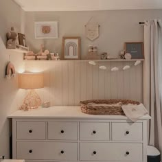 a white dresser sitting next to a window in a room