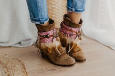 Infuse your cowgirl boots with a touch of femininity with our Pink Western Cowgirl Boot Cuffs. These stylish accessories offer a blend of rodeo-ready fashion and trendy leg warmers, elevating your cowgirl chic ensemble. Adorned with a fashionable pink hue, these cuffs are the perfect statement piece to enhance your Western-inspired footwear. Embrace the trendsetting rodeo attire with these unique and stylish boot accessories. SPECIFICATIONS * Tribal boot covers  * Features a camel-colored feathe Country Style Fall Festival Boots, Bohemian Knee-high Boots For Fall, Western Ankle Booties For Winter, Bohemian Rodeo Fall Boots, Bohemian Brown Boots For Western-themed Events, Bohemian Rodeo Boots For Fall, Bohemian Moto Boots For Festival In Fall, Bohemian Knee-high Boots For Festivals, Bohemian Fall Rodeo Boots