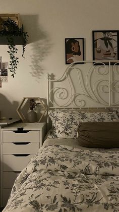 a bedroom with a bed, dresser and pictures on the wall