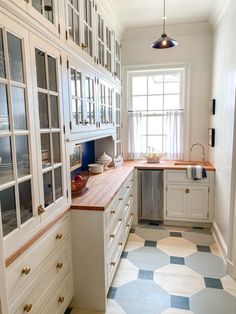 a kitchen with white cabinets and blue checkered flooring on the tiles in it