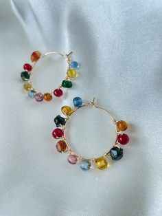 1.25"x 1.25" Copper wire hoop earrings, strung with rainbow colored glass beads. Colorful Dangle Hoop Earrings With Ear Wire, Multicolor Wire Wrapped Round Earrings, Rainbow Wire Wrapped Round Jewelry, Colorful Dangle Hoop Earrings, Nickel-free Multicolor Everyday Jewelry, Everyday Multicolor Nickel-free Jewelry, Multicolor Wire Wrapped Earrings With Round Beads, Multicolor Hoop Earrings With Ear Wire, Everyday Rainbow Round Jewelry