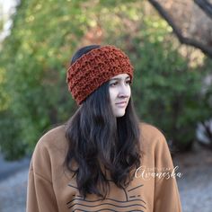 a woman with long hair wearing a knitted headband and looking off to the side