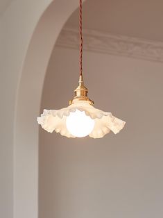 a light fixture hanging from a ceiling in a room with white walls and arched doorways