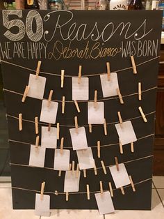 a sign with clothes pins attached to it that says 50 reasones we are happy and search santa was born