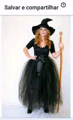 a woman in a witch costume holding a broom and wearing a black dress with a long tulle