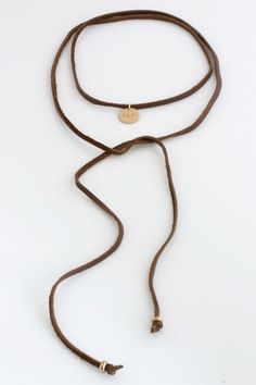 "The Leather Wrap Boho Choker is a fun and versatile necklace you can wear many different ways! Personalize the 1/2\" disc with initials, symbols, date, etc... *CHOOSE between an engraved, hammered or blank disc and BLACK or BROWN leather - premium 13mm (1/2\") 14k Gold Filled or Sterling Silver disc - GORGEOUS signature satin finish on the disc - 47\" genuine leather wrap with 14k gold filled or sterling silver bead at each end - hand made with care and love at our studio in San Diego, CA USA L Brown Adjustable Festival Jewelry, Brown Adjustable Jewelry For Festivals, Adjustable Everyday Choker, Brown Adjustable Choker Necklace, Brown Lariat Jewelry For Gifts, Adjustable Cord Brown Necklace For Everyday, Brown Necklace With Adjustable Cord For Everyday, Brown Adjustable Cord Necklace For Everyday, Brown Lariat Jewelry For Festival