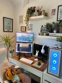 a computer desk with two monitors and a stuffed animal