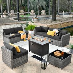 an outdoor living room with grey wicker furniture and yellow pillows on the couches