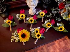 sunflowers and other flowers are arranged on a table next to an angel statue