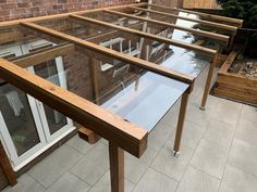 a glass and wood structure on the roof of a building with brick buildings in the background