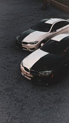 two cars parked next to each other in a parking lot with black and white stripes on them