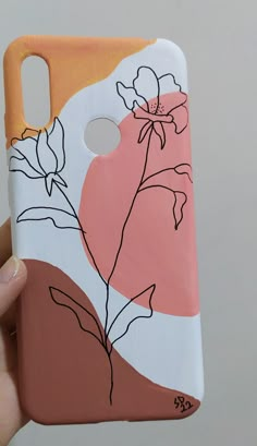 a hand holding up a phone case with flowers painted on it