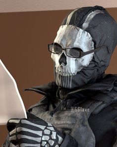 a man dressed in black and white with a skull mask holding a computer mouse next to his hand